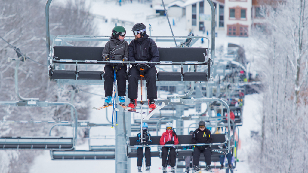 Several skiers riding the ski lift at Mount St. Louis Moonstone ski resort.