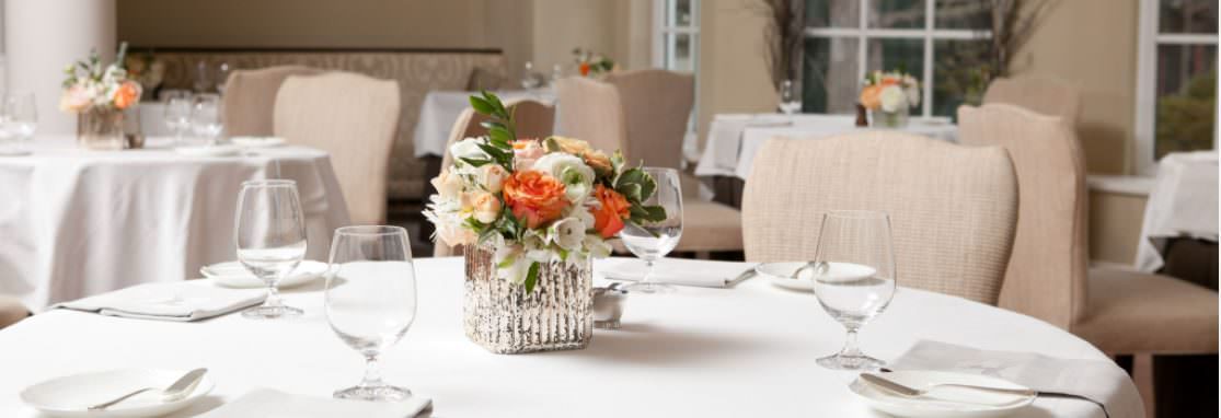 Langdon Hall Dining Room, sillas alrededor de mesas redondas con mantelería blanca, decoradas con centros de flores