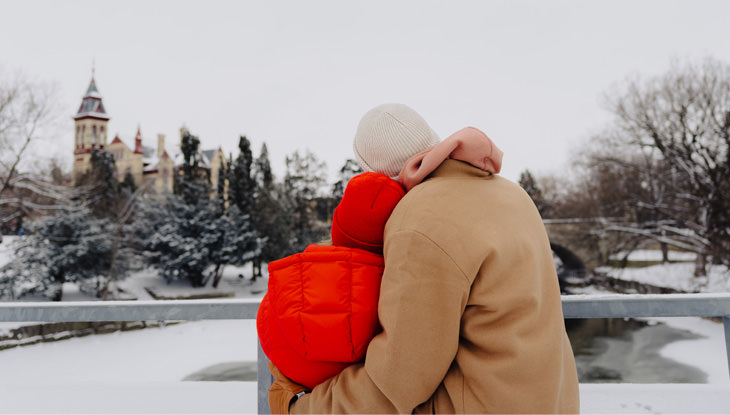 una pareja abrazándose frente a un edificio histórico