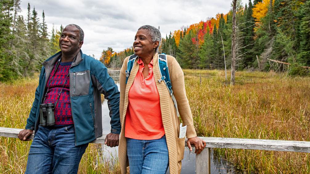 A couple enjoying fall colour and birdwatching in a park