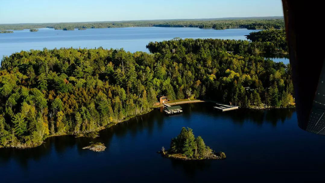 うっそうとした荒野、清らかな水、ウッズ湖の人里離れたロッジを上から眺める
