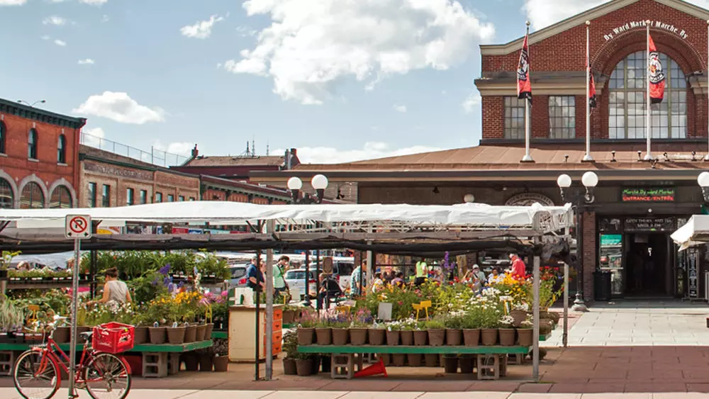 Vue des étals du marché et de la façade des bâtiments du marché By.