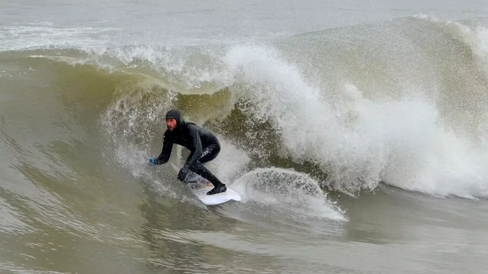 서퍼가 온타리오주의 큰 호수 중 하나에서 큰 파도를 타고 있습니다.