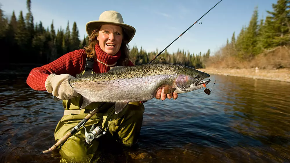 Una mujer sosteniendo un pez que pescó en el Lago Superior.