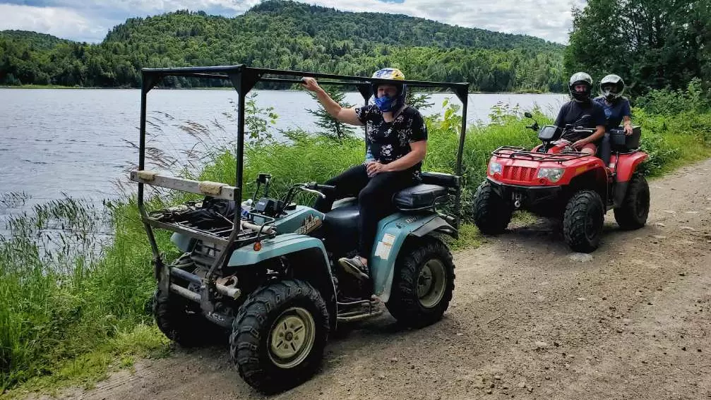 물가의 지형을 주행하는 두 대의 ATV.