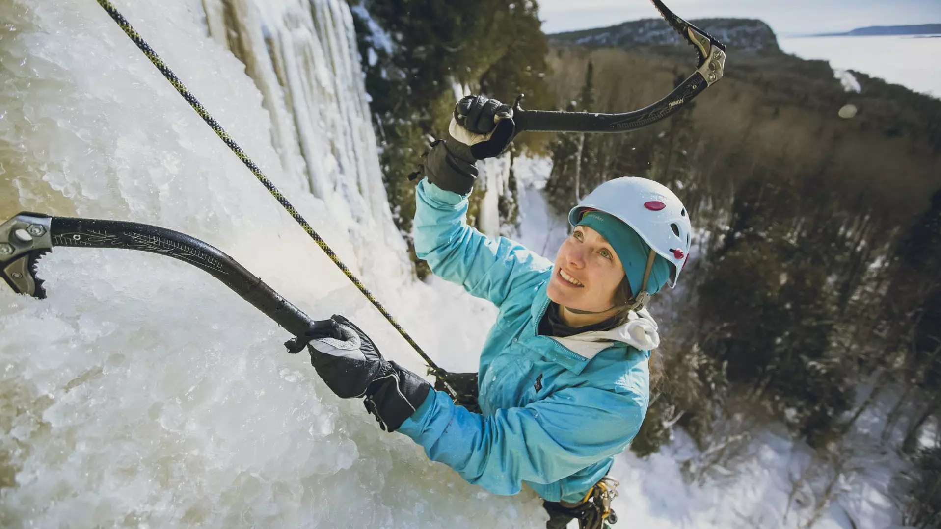 Eine Frau besteigt mit Eispickeln einen Eisfall in Nipigon.
