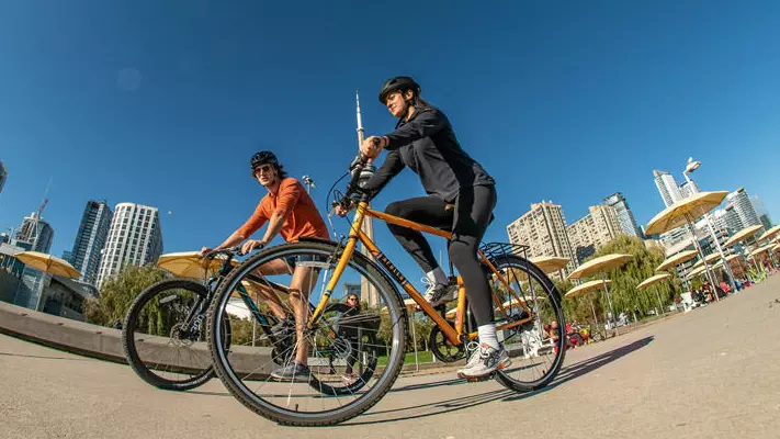 Dos personas andando en bicicleta en el centro de Toronto.