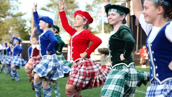 타탄 체크 무늬를 입고 스코틀랜드 전통 춤을 추는 젊은 여성들의 줄