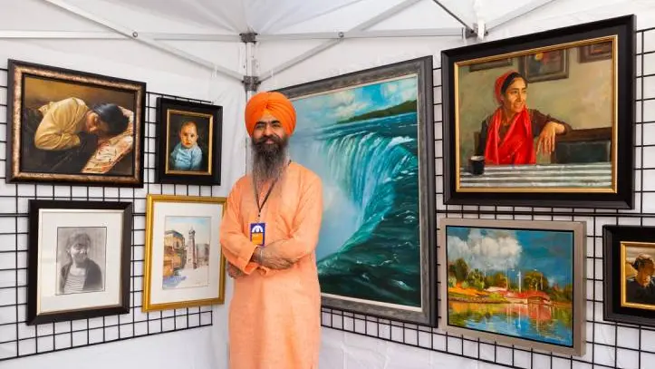 Ein Künstler posiert vor seinem Kunstwerk