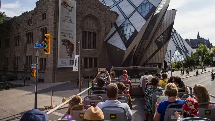 오픈탑 버스 위에 앉아 ROM을 지나가는 사람들.