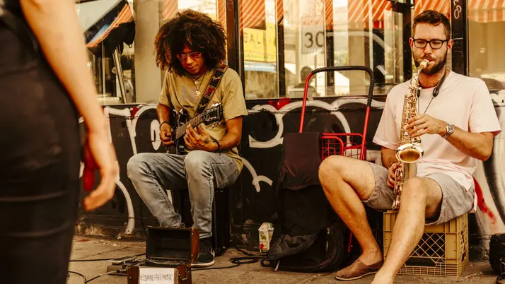 Deux musiciens se produisent devant une vitrine du marché de Kensington.