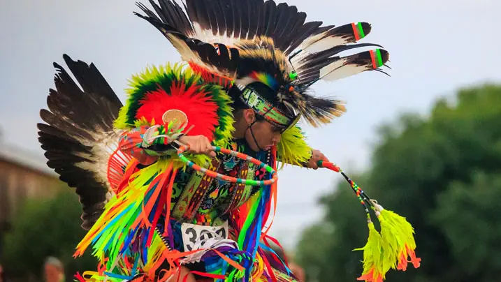 A man performing an Indigenous dance at a Summer Solstice celebration.