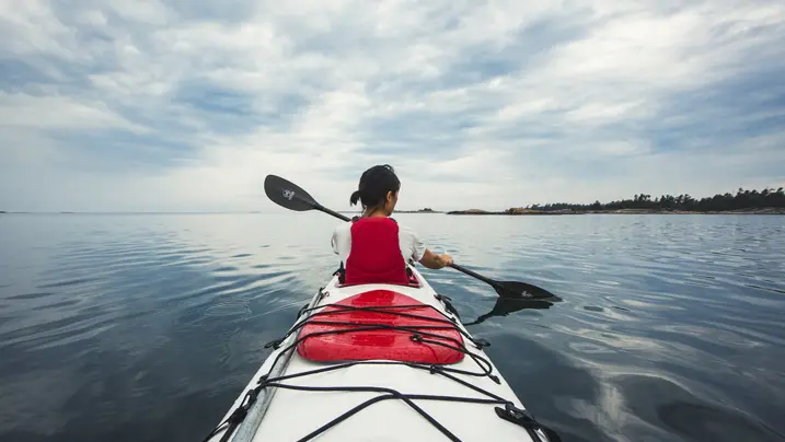 조지아 만의 아름답고 고요한 물 위에서 혼자 카약을 타는 여성.