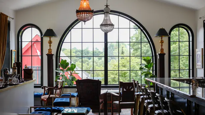 Grandes fenêtres, mobilier élégant et bar chic dans une salle de dégustation d’une distillerie.