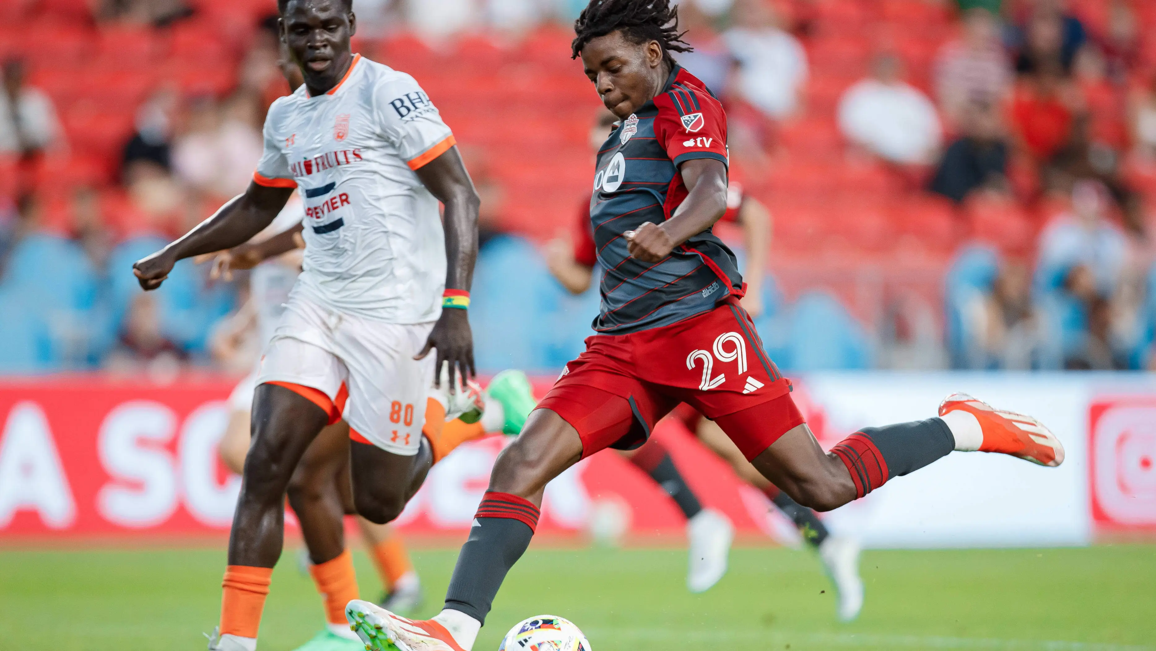 Players on a soccer field in a soccer stadium
