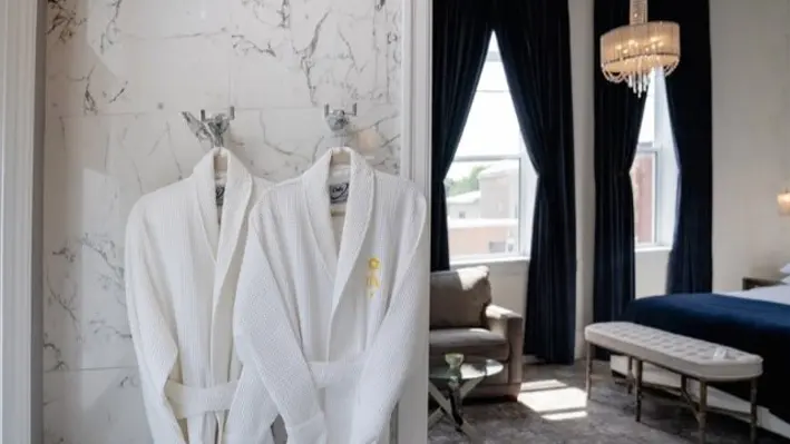 Zwei Bademäntel hängen in einer luxuriösen Boutique-Hotelsuite.