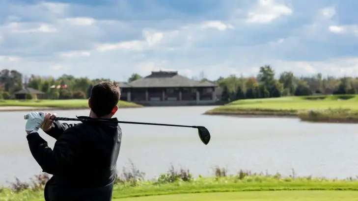 Un golfista hace swing con su palo de golf.