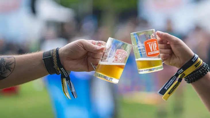 Los asistentes a un festival de cerveza brindan con jarras de cerveza.