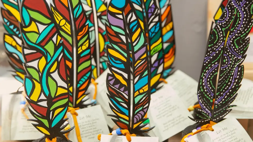 先住民アーティストが制作した、色鮮やかに彩色されたガラスの羽根の展示。