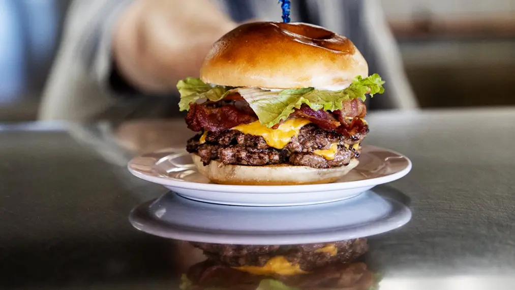 셰프가 Sault Ste. Marie의 한 레스토랑에서 육즙이 가득한 햄버거를 제공하고 있습니다.