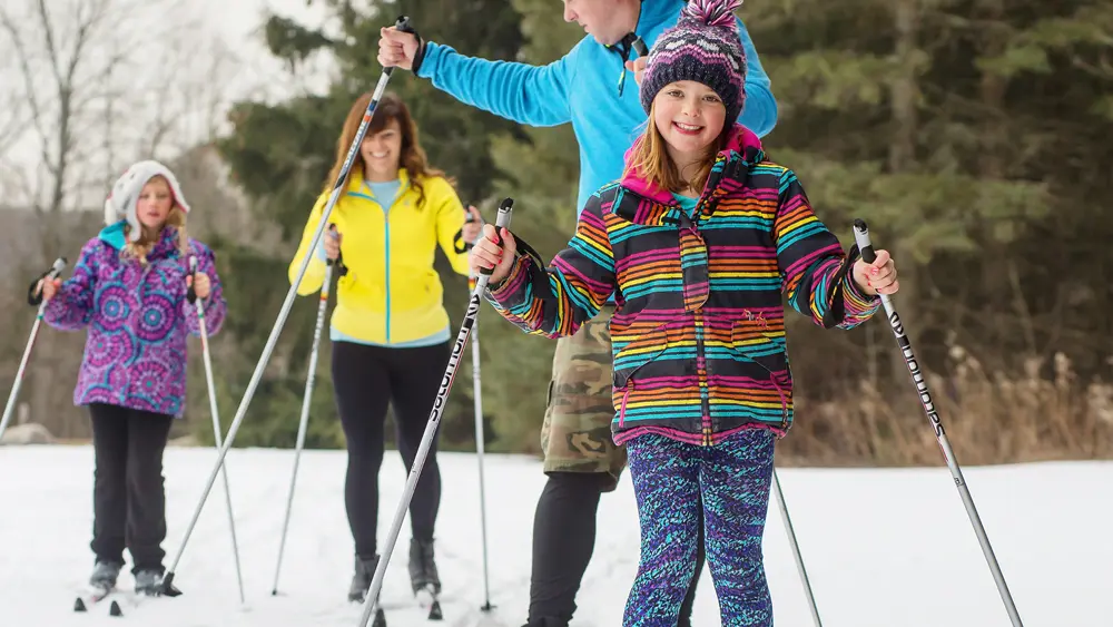 Una familia de cuatro personas practicando esquí de fondo en el área de conservación de Albion Hills, cerca de Caledon.