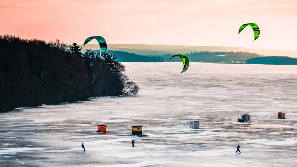 Les gens font du kite sur glace et pêchent sur glace sur le lac Rice gelé.
