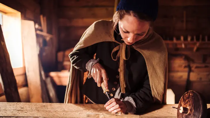 Une femme en habit d’époque au site historique extérieur de Sainte-Marie-des-Hurons.