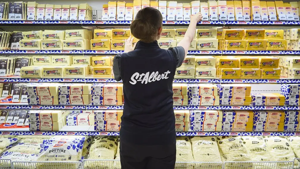 オタワ近郊のセントアルバートチーズショップで、ある女性がチーズの種類を揃えている。