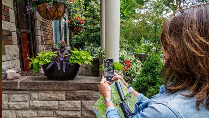 庭園ツアーで庭の写真を撮っている女性。