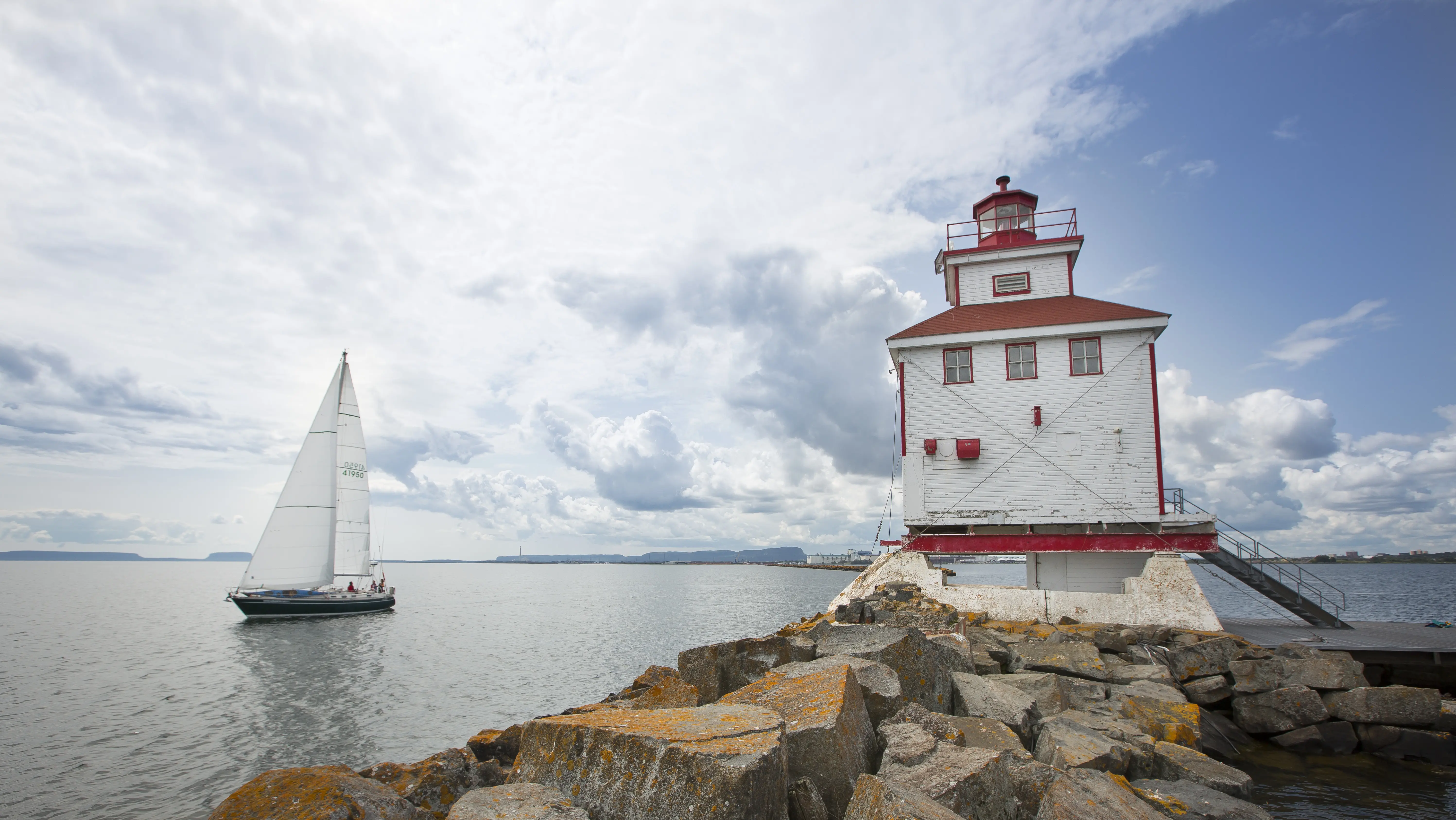 The white with red trimming Thunder Bay lighthouse overlooking the water.