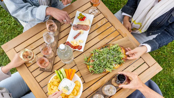 Quatre personnes assises à une table sur laquelle un assortiment de dégustation de vins est servi avec charcuteries et grignotines à l’établissement vinicole Georgian Hills Vineyards près de Blue Mountain.