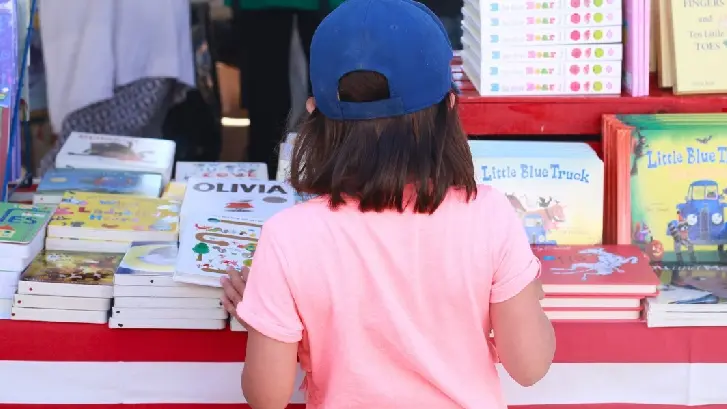 Ein kleines Mädchen schaut sich bei Word on the Street Bücher an
