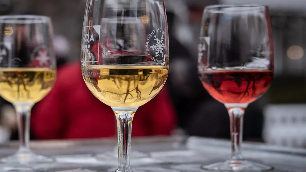 Three glasses of Icewine on a frozen bar during the Niagara Icewine Festival.