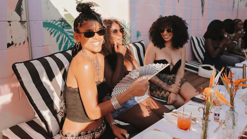 Drei Frauen unterhalten sich auf einer Außenterrasse