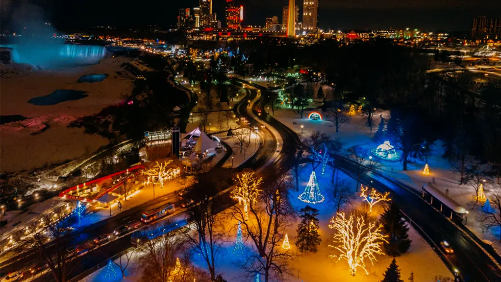 The skyline of Niagara Falls and Clifton Hills are lit up at night with colourful blue and gold lights for the holidays.