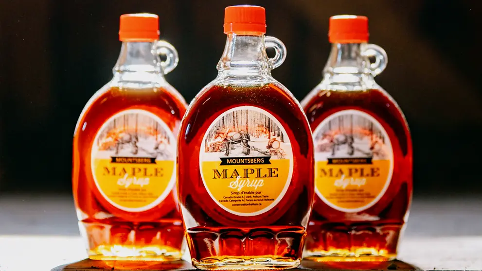 Three bottles of maple syrup are displayed.