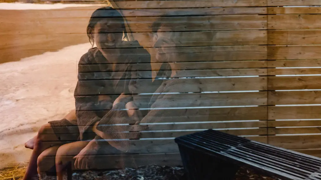 Zwei Frauen lachen und unterhalten sich angeregt beim Saunabesuch im Wander the Resort in Prince Edward County.