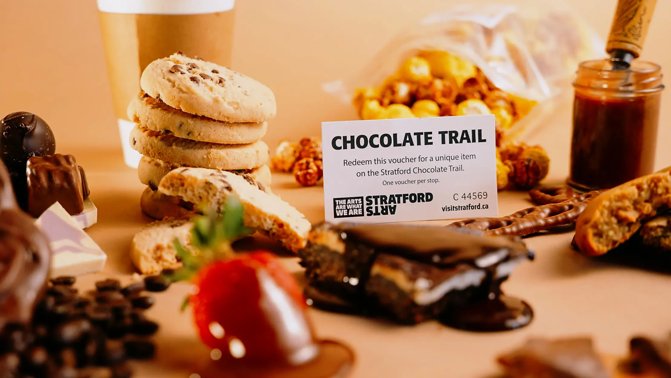 수제 초콜릿과 디저트들이 커피 원두와 코코아 가루와 함께 테이블 위에 보기 좋게 놓여 있습니다.