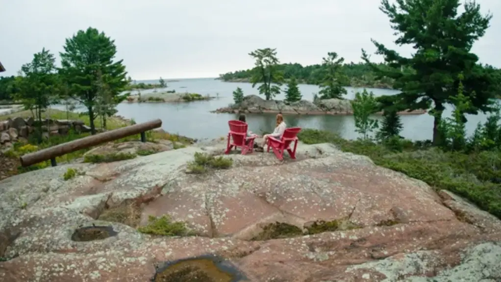 Un homme et une femme se détendant sur des chaises longues au bord d'un lac calme.