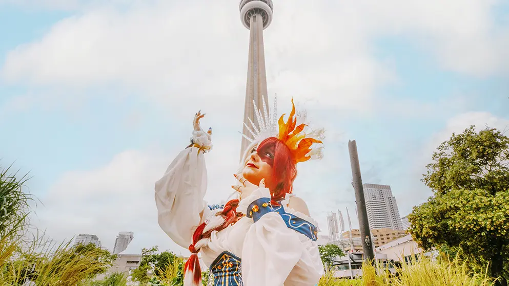 Personne costumée prenant la pose avec la Tour CN en arrière-plan.