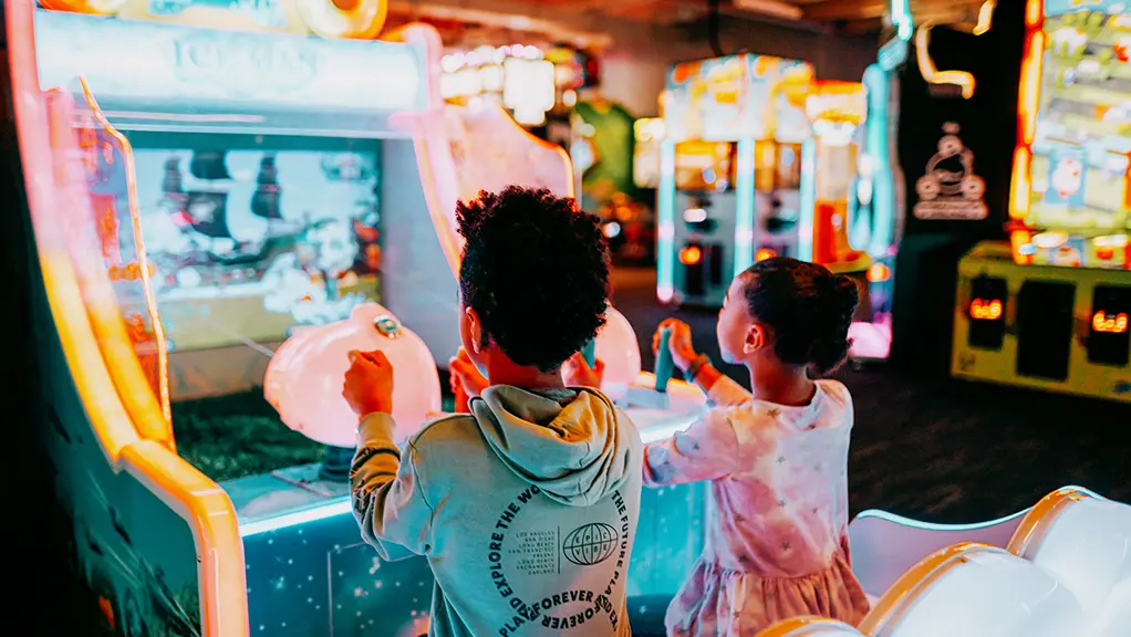 Deux jeunes enfants s'amusent à jouer à un jeu d'arcade à The Factory, à London, en Ontario.