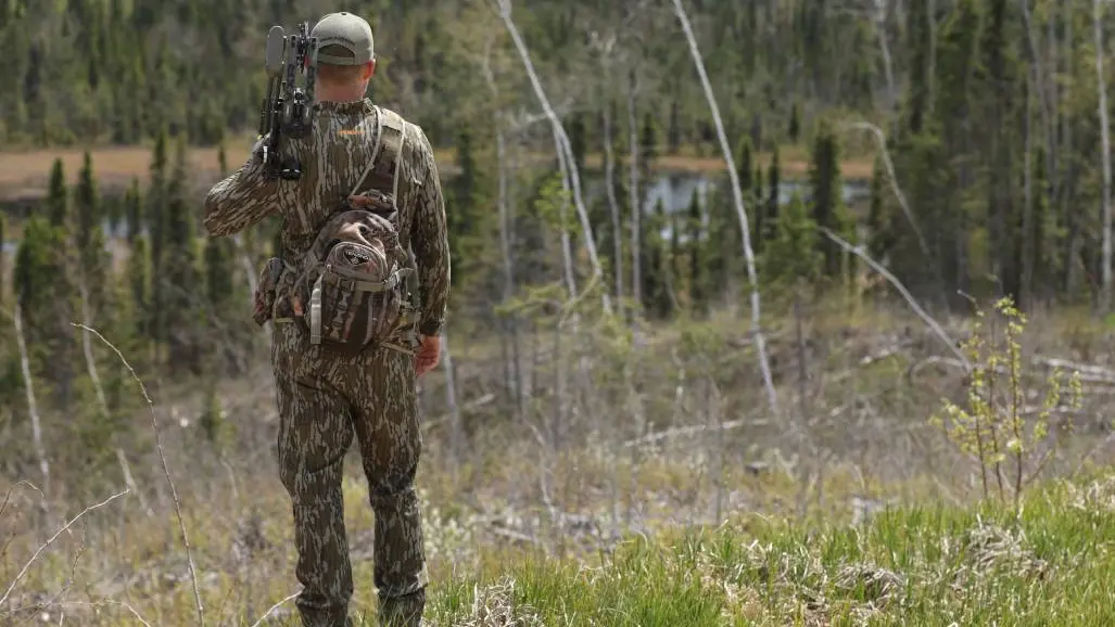 Un hombre con ropa de camuflaje en una excursión de caza con arco en la región de Algoma Country.
