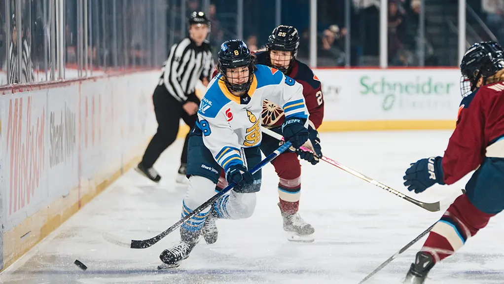 Joueuse des Sceptres de Toronto affrontant deux femmes de l’équipe adverse dans un match de hockey.
