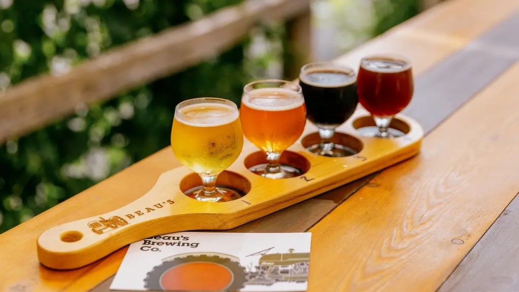 木製のトレイに小皿と合わせて提供される、数種類のビール