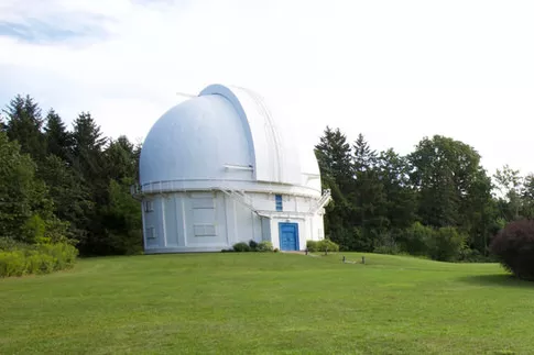 데이비드 던랩 천문대(David Dunlap Observatory)의 일부인 두 건물과 깃대는 잘 관리된 잔디밭과 정원으로 둘러싸여 있습니다.