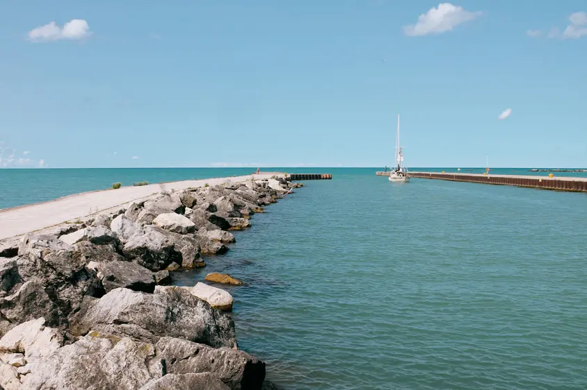 휴런 호수의 베이필드 항구 입구에 있는 청록색 바닷물로 뻗어 있는 돌 방파제와 부두.