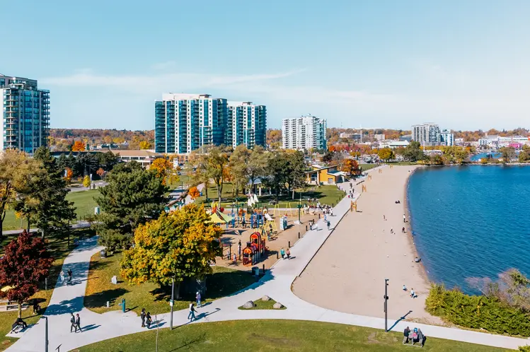 놀이터, 산책로, 켐펜펠트 만을 따라 펼쳐진 모래사장이 있는 배리의 센테니얼 공원과 해변의 공중 사진.