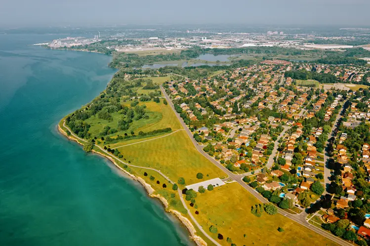 Aerial view of Ajax Waterfront Park along Lake Ontario on a sunny summer day, showcasing green spaces, walking trails, and nearby residential areas.