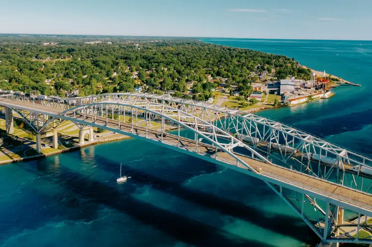푸른 세인트 클레어 강을 가로지르는 블루 워터 다리의 공중 사진. 사니아와 포트 휴런을 연결하며 푸른 해안선이 펼쳐져 있습니다.