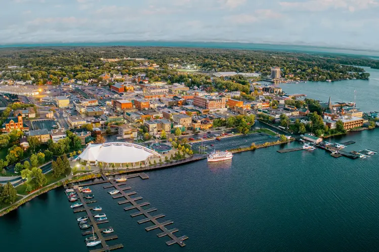 Luftaufnahme von Kenora, Ontario bei Sonnenuntergang, mit an der Küste angedockten Booten und sanften violetten Wolken über dem Lake of the Woods.